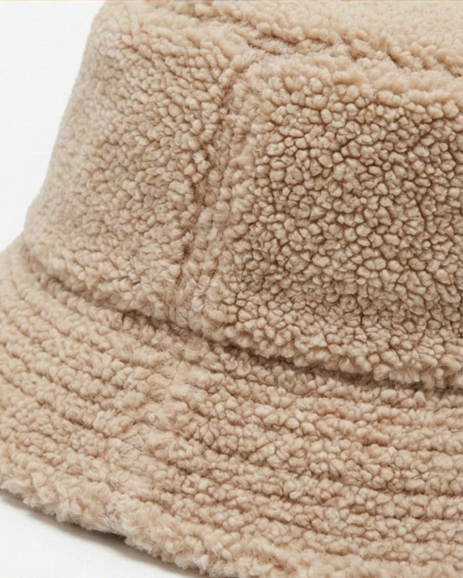 Beige sherpa fleece bucket hat with textured, cozy fabric closeup