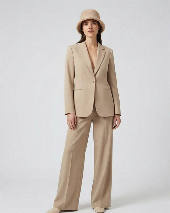 Woman in beige pantsuit and bucket hat, modern minimalist fashion style