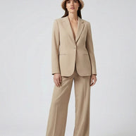 Woman in beige pantsuit and bucket hat, modern minimalist fashion style