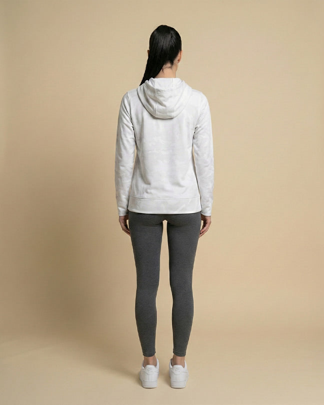 Woman wearing white hoodie, gray leggings, and white sneakers, shown from the back.