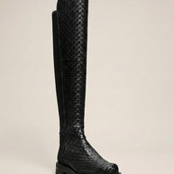 Black knee-high woven leather boot with textured pattern on a neutral background